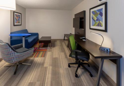 a room with a desk and chairs in a room at Holiday Inn Express Hotel & Suites-St. Paul by IHG in Vadnais Heights