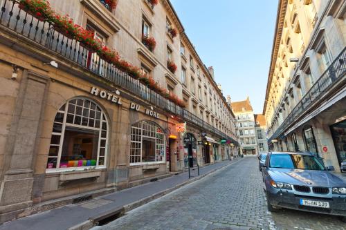 a car parked on a cobblestone street next to buildings at Hotel Du Nord in Besançon