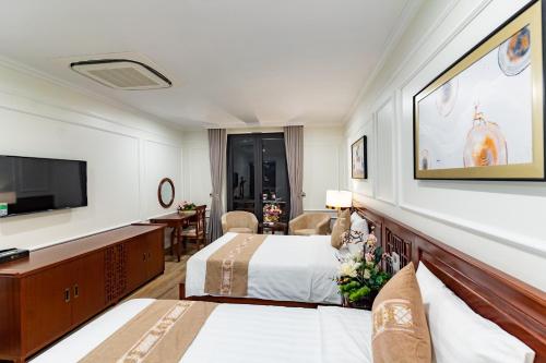 a hotel room with two beds and a flat screen tv at TỪ SƠN LUXURY 2 HOTEL in Ðại Dính