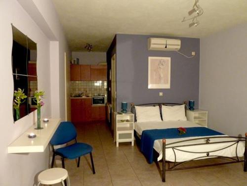 een slaapkamer met een bed met een blauwe muur bij The Seasons of Nickolas in Ayia Evfimia
