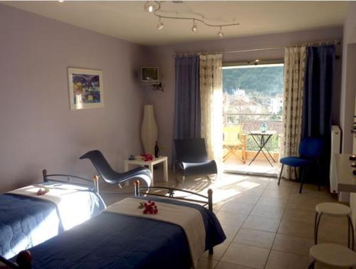a hotel room with two beds and a balcony at The Seasons of Nickolas in Ayia Evfimia