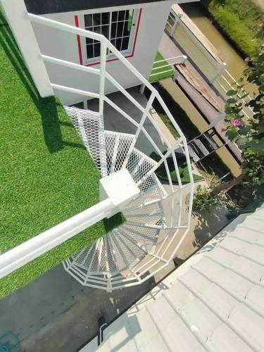 an overhead view of a white spiral staircase on a house at ข้าวทุ่งเบ็ญจาโฮมสเตย์ in Ban Hat Phang