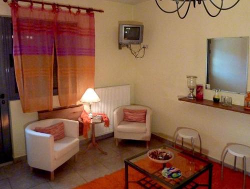 a living room with two chairs and a table at The Seasons of Nickolas in Ayia Evfimia