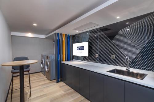 a kitchen with a sink and a washing machine at Holiday Inn Express Ningbo City Center by IHG in Ningbo
