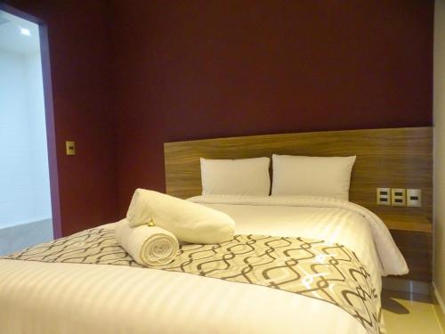 a bedroom with a large bed with white sheets and pillows at Hotel Luma by Kavia in Cancún