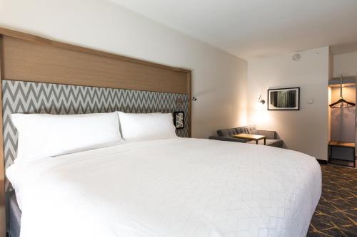 a large white bed in a hotel room at Holiday Inn Greenville - Woodruff Road by IHG in Greenville
