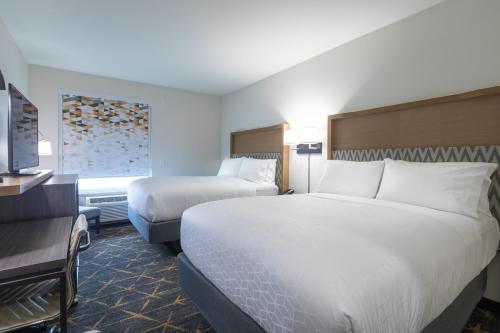 a hotel room with two beds and a television at Holiday Inn Greenville - Woodruff Road by IHG in Greenville