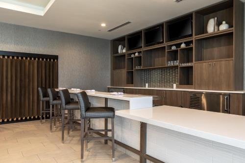 a restaurant with a bar with stools and cabinets at Holiday Inn Greenville - Woodruff Road by IHG in Greenville