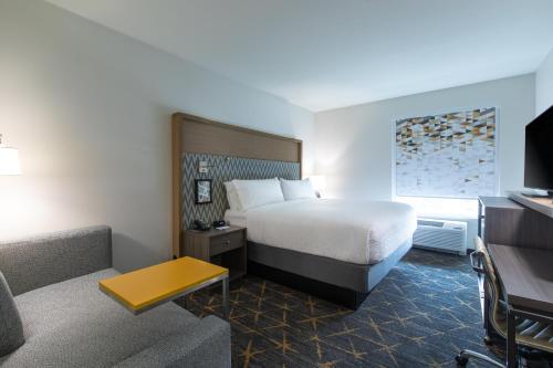 a hotel room with a bed and a couch at Holiday Inn Greenville - Woodruff Road by IHG in Greenville