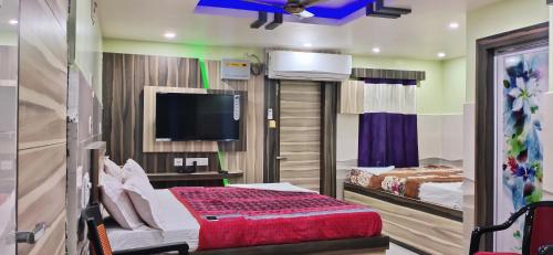 a hotel room with a bed and a tv at LN BEACH Homestay in Puri