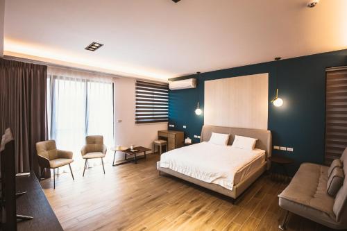 1 dormitorio con cama, sofá y sillas en Coolbreeze homestay, en Huxi