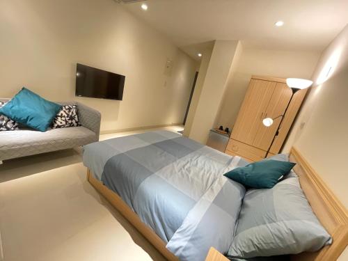 a bedroom with a bed and a couch at Candy House in Zhushan