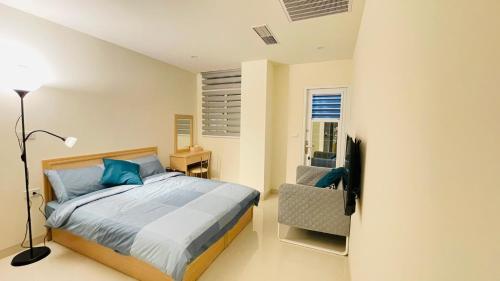 a bedroom with a bed and a chair at Candy House in Zhushan