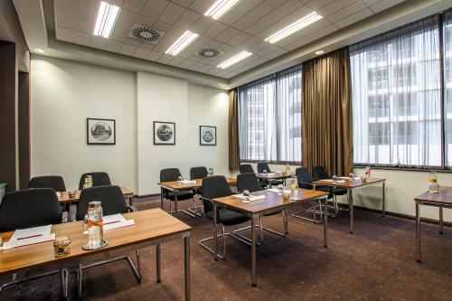 a conference room with tables and chairs and large windows at Crowne Plaza Birmingham City by IHG in Birmingham