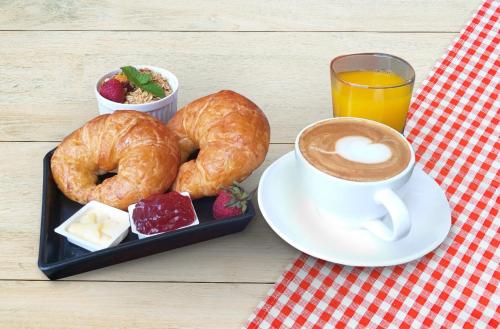 une assiette de beignets et une tasse de café sur une table dans l'établissement D Varee Montara Thonglor 25, à Bangkok