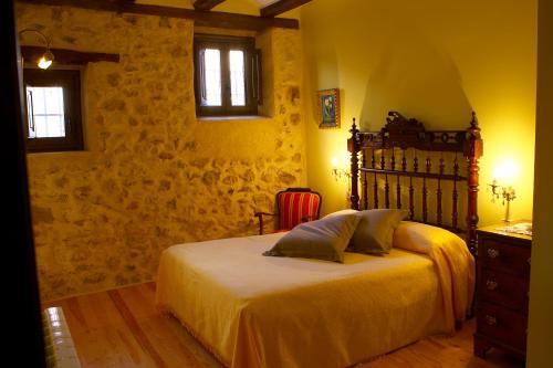 a bedroom with a bed and a dresser and two windows at Hotel La Val in Jarque de la Val