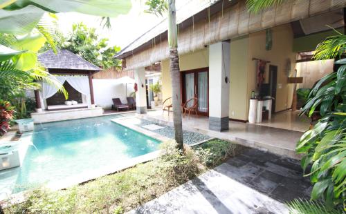 
a house with a pool and a balcony at Nike Villas in Sanur

