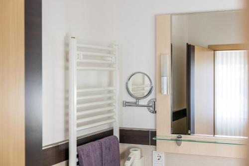 a bathroom with a mirror and a purple towel at Hotel Germania in Stadtallendorf