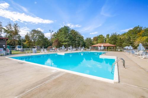 a large swimming pool with chairs and a gazebo at Rondout Valley Camping Resort Deluxe Park Model 3 in Accord