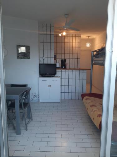 une chambre avec une cuisine et une table et une chambre avec un lit dans l'établissement le rêve RESIDENCE PORT LA MADRAGUE Cap D Agde, au Cap d'Agde