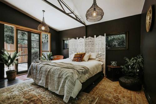 um quarto com uma cama grande com almofadas em Dark Moon Cottage. Luxurious. em Yandina Creek