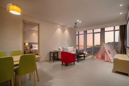 a living room with a couch and a table and chairs at Holiday Inn Express Qingdao Innovation Park by IHG in Qingdao