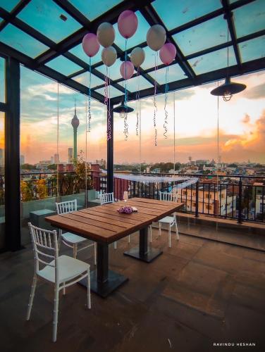 a wooden table and chairs on a roof with a view at The Den 23 in Maradana