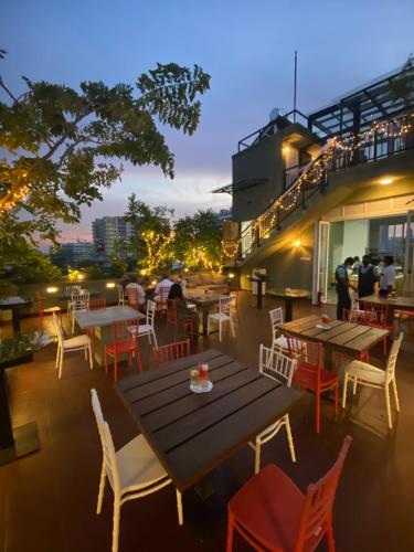 a patio with tables and chairs on a roof at The Den 23 in Maradana