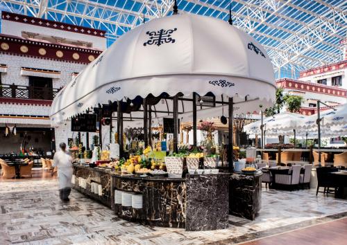 a man walking past a fruit stand in a mall at InterContinental Lhasa Paradise by IHG in Lhasa