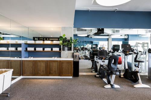 a gym with treadmills and exercise equipment in a room at Kimpton Rowan Palm Springs Hotel by IHG in Palm Springs