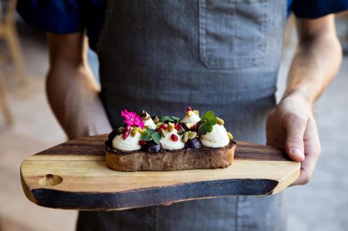 a person holding a piece of bread with a dessert on it at Kimpton Rowan Palm Springs Hotel by IHG in Palm Springs