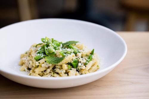 a white bowl of rice with greens on a table at Kimpton Rowan Palm Springs Hotel by IHG in Palm Springs