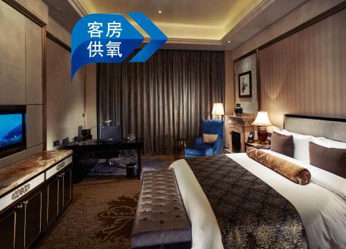 a hotel room with a large bed and a desk at InterContinental Lhasa Paradise by IHG in Lhasa