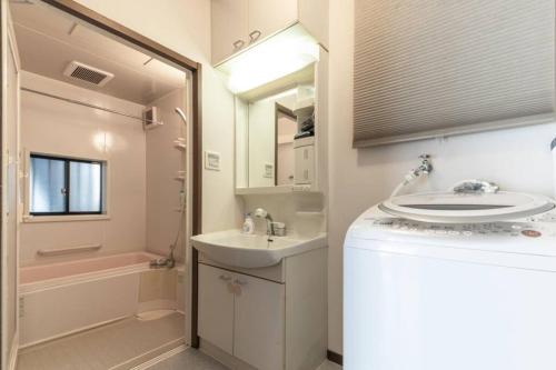 a bathroom with a sink and a toilet and a tub at Urban Stay Shinagawa in Tokyo