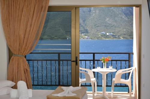 a room with a balcony with a table and a view at Plaza Hotel in Masouri