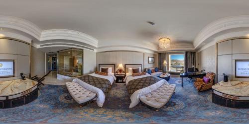 a hotel room with two beds and a living room at InterContinental Lhasa Paradise by IHG in Lhasa
