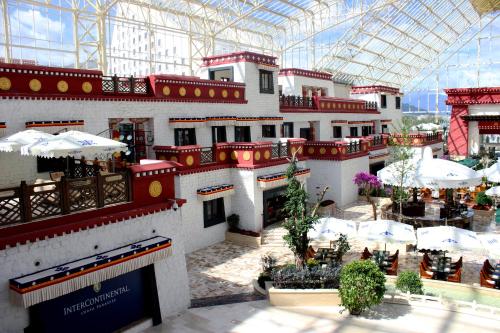 a large building with tables and umbrellas in a mall at InterContinental Lhasa Paradise by IHG in Lhasa