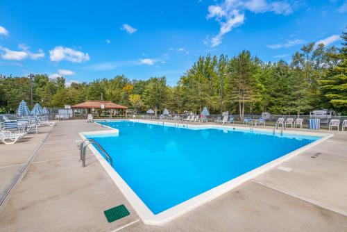 a large swimming pool with chairs and trees at Rondout Valley Camping Resort Deluxe Park Model 11 in Accord