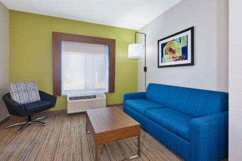 a living room with a blue couch and a chair at Holiday Inn Express and Suites Three Rivers by IHG in Three Rivers