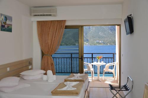 a bedroom with a bed and a balcony with a view at Plaza Hotel in Masouri