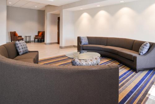 a living room with two couches and a table at Holiday Inn Poplar Bluff by IHG in Poplar Bluff