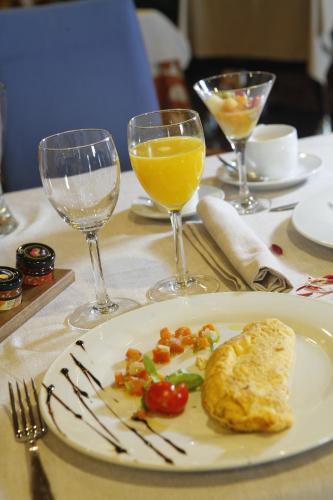 a plate of food on a table with glasses of wine at Hotel Escuela Santa Cruz in Santa Cruz de Tenerife