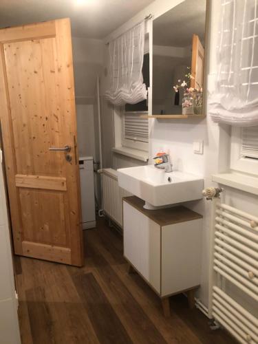 une petite cuisine avec un évier et une porte. dans l'établissement Ferienhaus am Hahnenkopf, à Rübeland