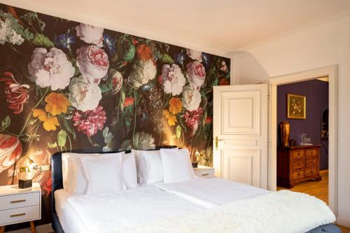 a bedroom with a floral wallpaper with a bed at Hotel Castel Rundegg (Adults Only) in Merano