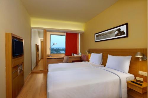 a hotel room with two beds and a television at ibis New Delhi Aerocity - An Accor Brand in New Delhi