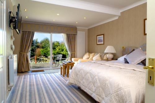 a bedroom with a bed and a couch and a window at Tyn Rhos Country House in Caernarfon