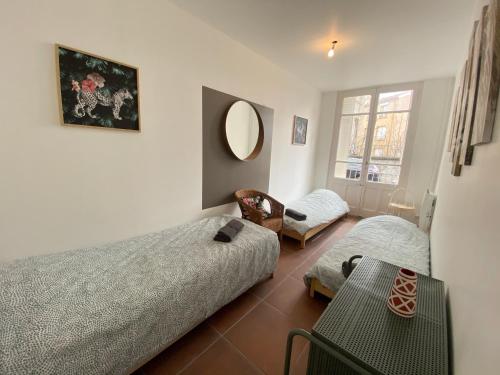 une chambre avec deux lits et un miroir dans l'établissement 021 CHIC & COSY GRAND APPART 84m2 HYPERCENTRE WIFI SMART TV NETFLIX, à Saint-Étienne