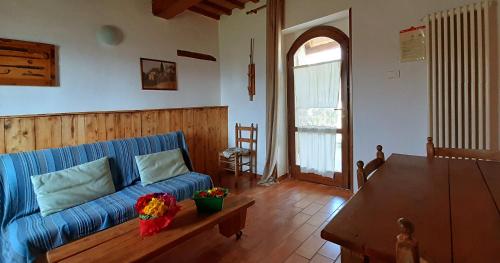 a living room with a blue couch and a table at Country House Ca' Vernaccia in Urbino