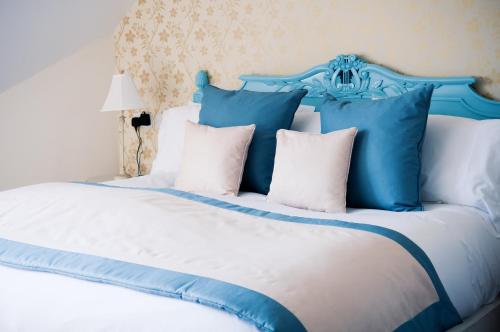 a blue and white bed with white pillows at Château Rhianfa in Menai Bridge