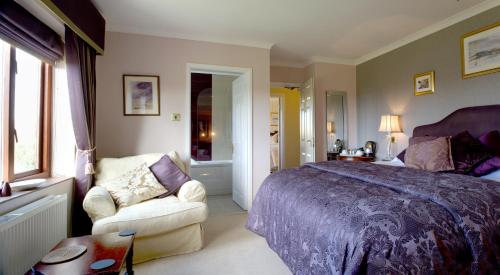 a bedroom with a bed and a chair at Tyn Rhos Country House in Caernarfon